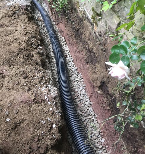 french drain in trench, uncovered